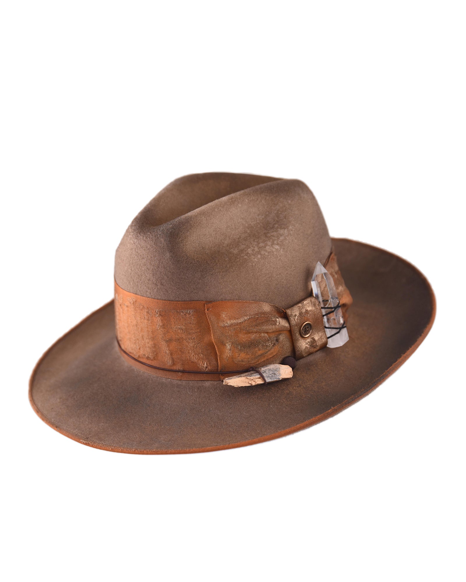 Wide-brim brown felt hat featuring a distressed leather band, silver buckle detail, and feather accent. A vintage-inspired design from Fallenbrokenstreet, crafted with rugged elegance and artisan texture for bold, timeless style.
