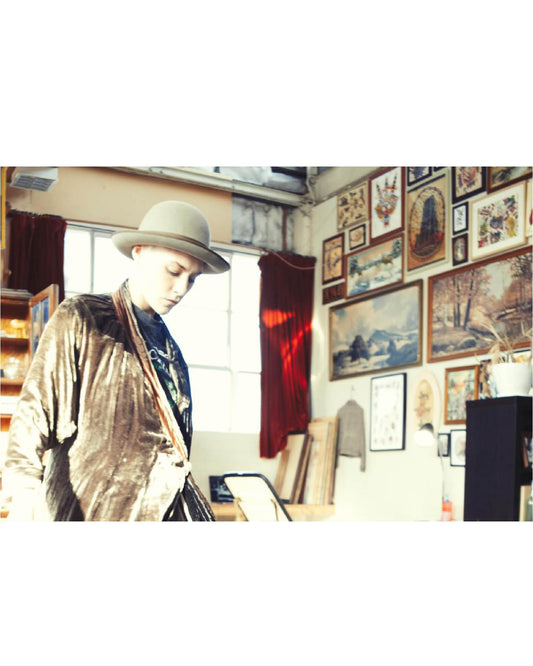 Model wearing The Bowler Felt Hat by FallenBROKENstreet. Grey wool felt hat with classic round crown and ribbon band, styled in a vintage-inspired setting.