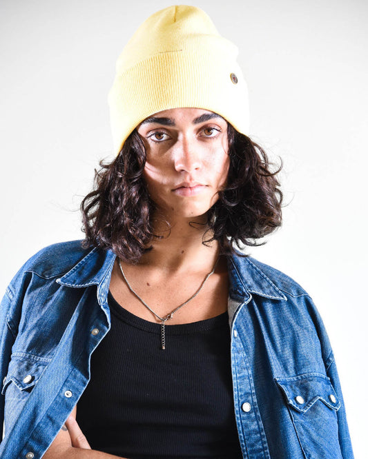 Model wears Bright yellow Buttercup Lucks Beanie, lightweight non-wool knit, unisex style with folded cuff.