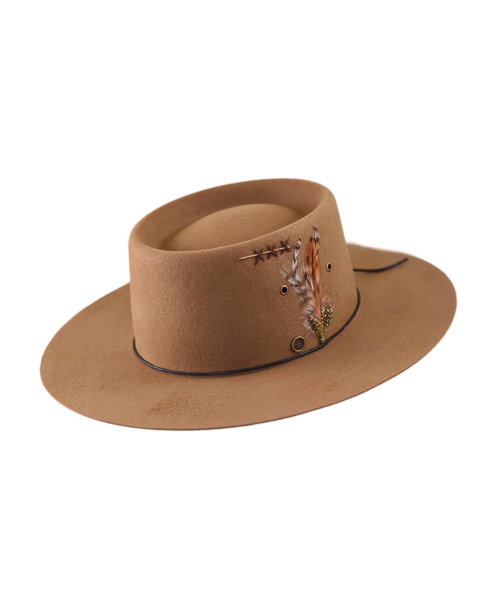 The Notebook hat in vintage tan shown front-on, highlighting its stiff wide brim, patina finish, waxed rope band, and custom feather—each piece unique.