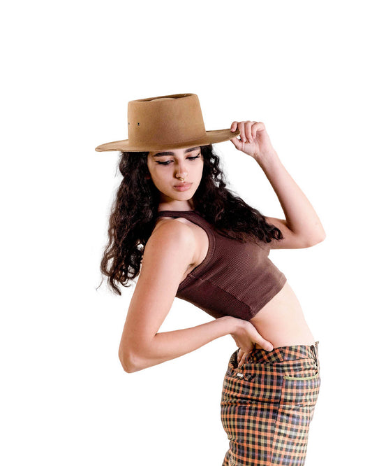 A woman in cropped top and printed skirt wears The Notebook in vintage tan, styled effortlessly for a sun-drenched, nostalgic vibe.