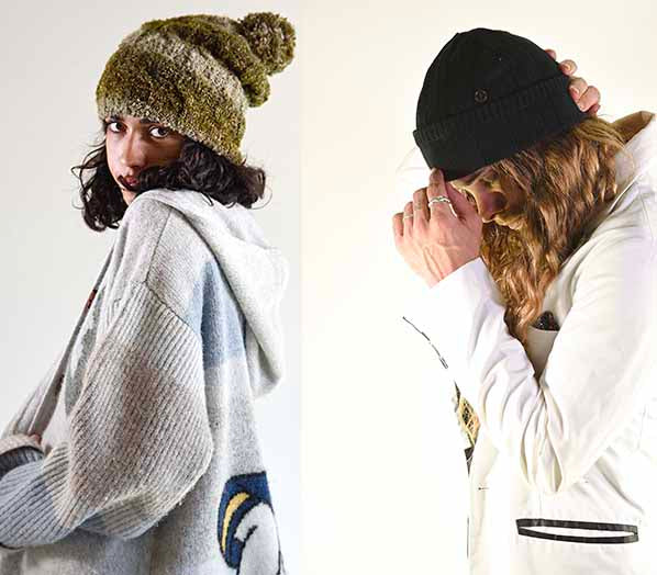 A man and women wear cosy winter clothes, both have a fallen broken street beanie on. They are wearing cosy winter fashion.