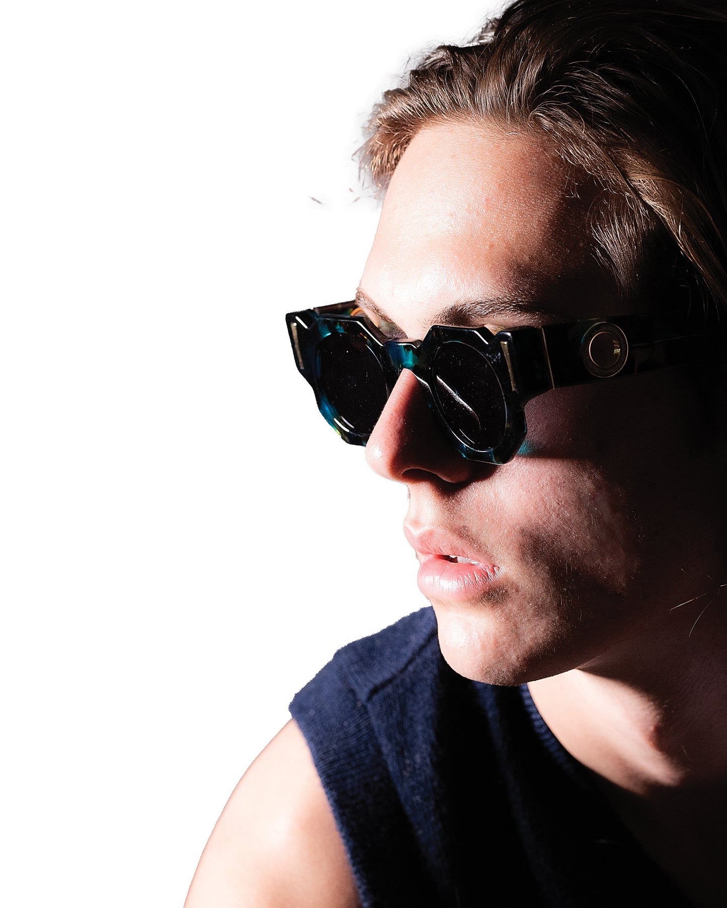 Male model wearing THE COSMOS – Galaxy/Black sunglasses, slightly turned with visible cheekbone and eye contact with camera. Black lenses and cosmic frame styling shown clearly.