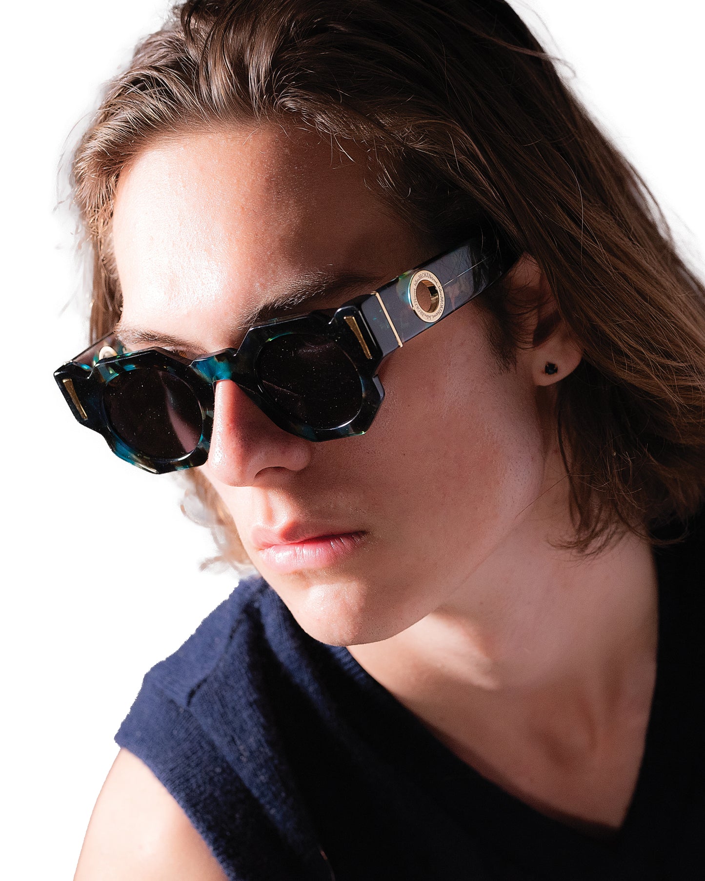 Editorial-style image of male model wearing THE COSMOS – Galaxy/Black sunglasses, showing how the shape frames the face. Strong lighting highlights polarised lenses and gold detailing. Perfect for unisex product presentation.