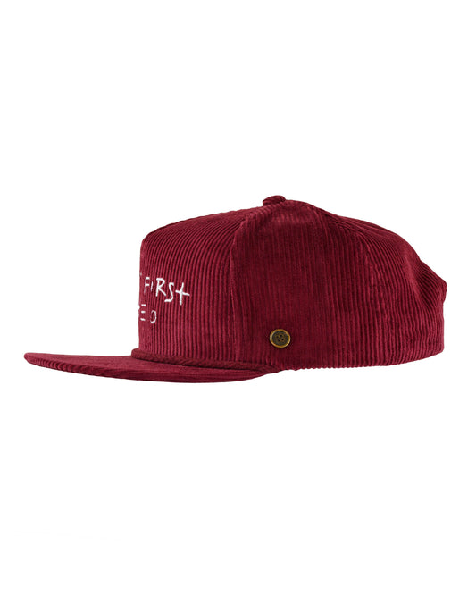 Side profile of the wine red corduroy cap showing the brim and custom embroidery.