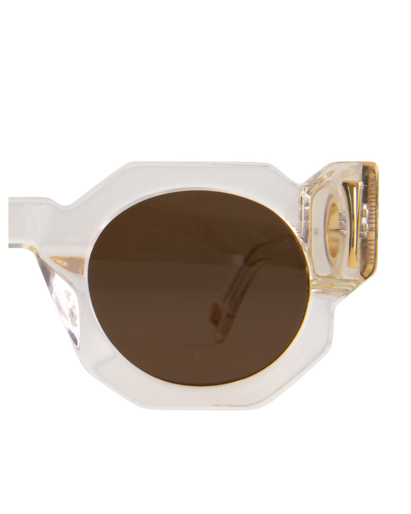 Studio image displaying the rounded amber lenses and clear temple arms of The Cosmos sunglasses. Close-up on the iconic Fallenbrokenstreet silhouette with gold hardware. Highlights comfort fit and timeless style.