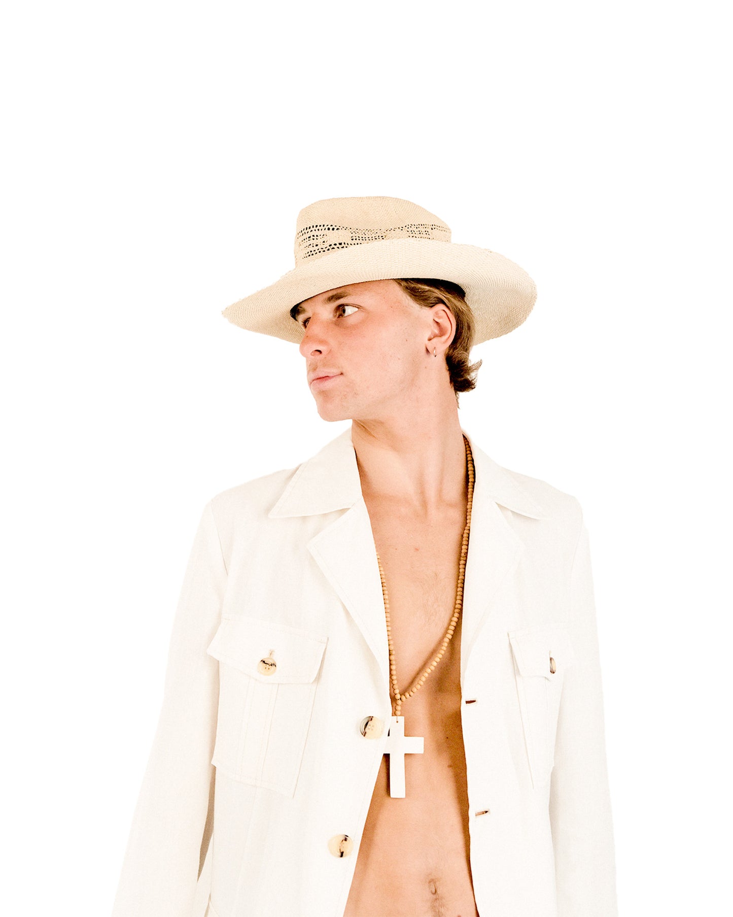 Model wearing The Lover Straw Hat – Natural, styled with a white jacket and open shirt for a fresh, sun-kissed look. The wide brim casts a soft shadow, highlighting its UPF functionality and timeless design perfect for long summer days.