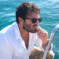 Angus Stone wearing Dope Lemon sunglasses while sitting on a boat in open water – Fallenbrokenstreet campaign.

