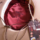Inside view of the Troubadour Felt Hat by FBS x Angus Stone. Featuring signature silky burgundy lining with Angus Stone design, cotton inner band for comfort, and leather chin strap. This image highlights craftsmanship, attention to detail, and the artistic spirit of the collaboration.
