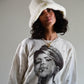Model wearing the white faux fur Cosmic Girl Bucket Hat with laid-back expression. The soft lines and full coverage crown offer both warmth and retro charm.

