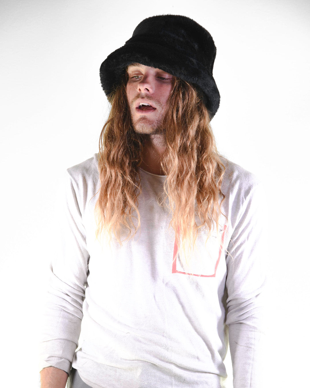 Person wearing a black hat and white shirt with red design on a white background