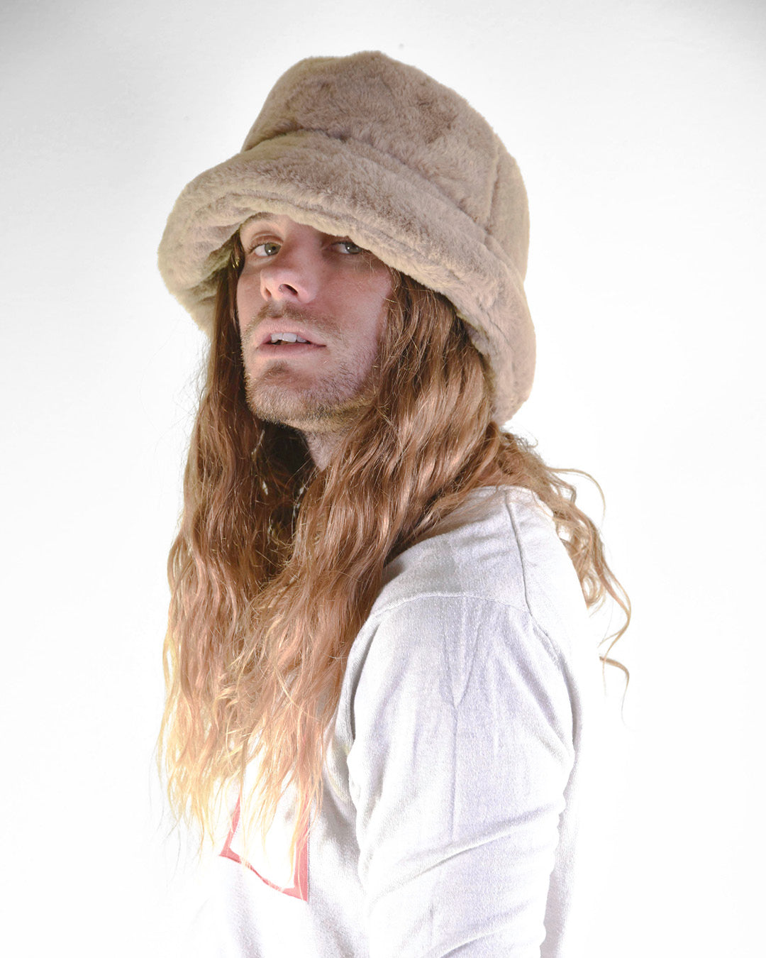 Person wearing a beige bucket hat with long hair on a white background