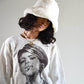 Side profile of the Cosmic Girl Hat in white, worn by model with loose waves. The bucket style and fluffy texture create a dreamy aesthetic perfect for colder days or music festivals.

