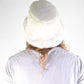 Person wearing a white knit hat on a plain background