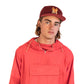 Man Wearing a red rain jacket and FallenBROKENstreet Stash Cap in Dingo Wine corduroy with stash pocket, embroidery, and signature button.