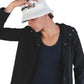 Model lifts the brim of The Rusty hat, revealing its flexible, travel-ready shape and standout embroidered branding. A perfect accessory for long road trips, coastal hangs, or streetwear cool.

