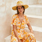 Seated model wearing FBS x Nine Lives mustard felt hat with flowing dress

