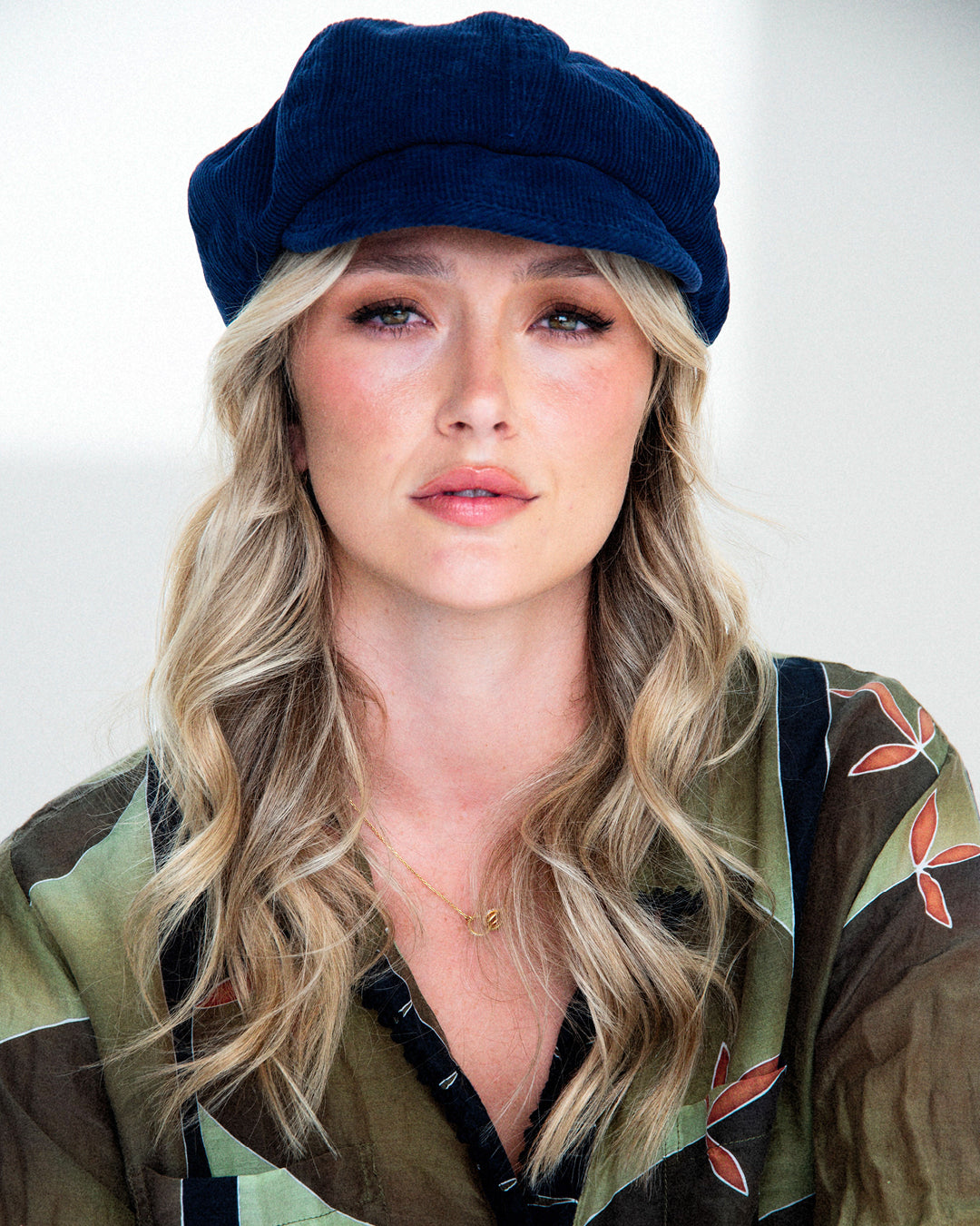 Woman wearing a navy blue cap with a plain background
