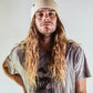 Front view of man with long hair FallenBROKENstreet Lucks Beanie in Beige, cosy ribbed knit wool blend with signature logo badge.