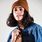 The Lucks Beanie in brown photographed on model, showcasing ribbed knit detail, logo badge, and snug unisex fit. FallenBROKENstreet wool blend beanie offers comfort, warmth, and understated streetwear style, perfect for festivals, coastal living, and layering with outerwear.