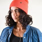 Model wears FallenBROKENstreet Lucks Beanie in Coral, ribbed knit, breathable non-wool with logo badge.