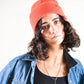 Front view of model wearing FallenBROKENstreet Lucks Beanie in Coral, ribbed knit, breathable non-wool with logo badge.