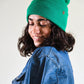 The Lucks Beanie in green photographed on model with long hair. FallenBROKENstreet ribbed knit beanie crafted from wool blend, featuring folded cuff and logo badge. Designed for comfort and durability, this unisex beanie offers warmth with a timeless style, suited for both urban wear and coastal adventures.