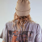 Back view of The Lucks Beanie in tan by FallenBROKENstreet, shown on model with long hair. Wool blend ribbed knit design with folded cuff and subtle logo badge. A timeless, unisex beanie offering warmth and comfort for year-round streetwear and layering.