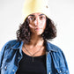Model wears Bright yellow Buttercup Lucks Beanie, lightweight non-wool knit, unisex style with folded cuff.
