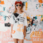 Model in oversized tee and FBS x Baptist red cap standing in front of painted wall.
