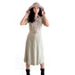 A woman wears the Melody hat in sand, styled with a soft neutral dress and boots. This wide-brim adventure hat by FallenBROKENstreet features a structured silhouette and leather chin strap. Perfect for exploring or daydreaming under the sun, it's made from 100% Australian wool felt and finished with UPF 50+ sun protection.


