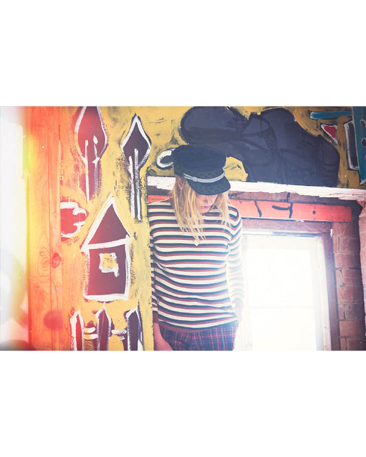 Model wearing The Naomi Cap – Navy Corduroy, captured in soft golden light. Vintage-inspired cord hat for effortless everyday wear.