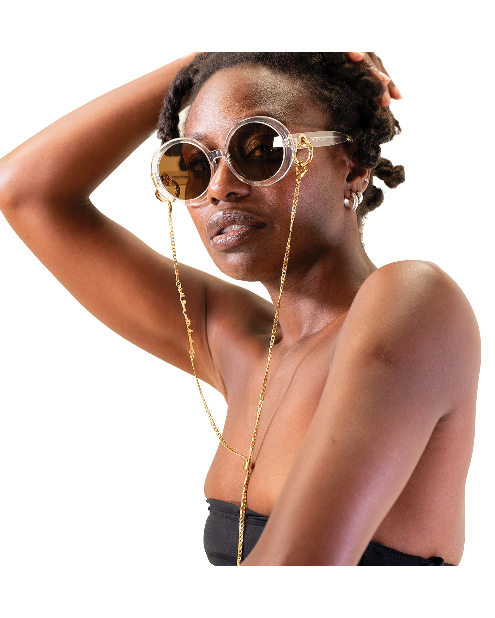 Model wears the "Kill Them with Kindness" 24k gold chain by FallenBROKENstreet with round black sunglasses. The chain drapes beautifully with its Y-shape design, adding both sophistication and a bold message. Ideal for elevating any sunglass look with subtle luxury.

