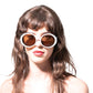 Model wearing THE ORBIT – White on Black sunglasses with round white frames and black lenses.

