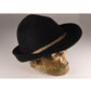 Angled shot of the black felt Peter hat on a sculptural skull, showcasing the depth of the crown and statement structure of the wide brim.

