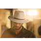 Model wearing the Crushable Ratatat in Mottle Grey under golden light. A stylish unisex travel hat handmade from 100% Australian wool felt, designed for easy packing and reshaping. Features include breathable eyelets and signature leather band.

