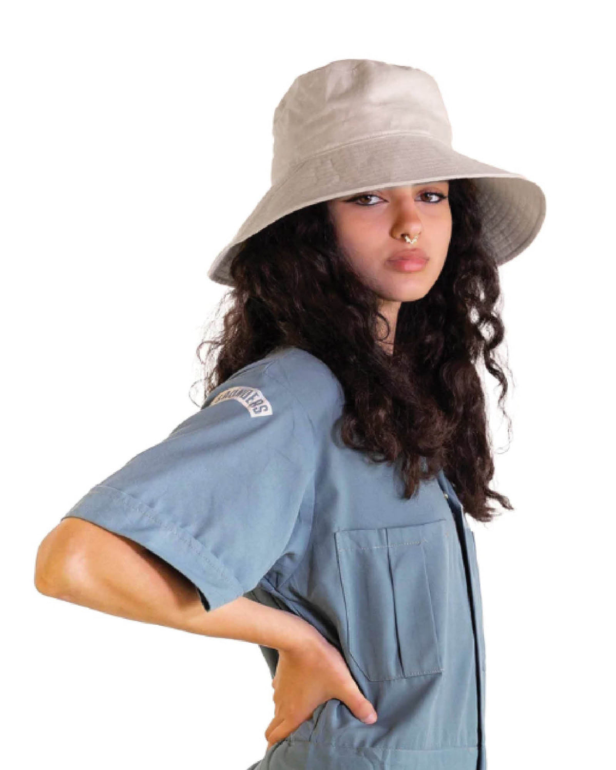 A female model wearing The Sandbar in natural linen, styled with a relaxed denim shirt. The image captures the soft drape of the hat’s semi-floppy brim and minimalist design, suited to sun protection and everyday wear. A lightweight staple from the bucket hats collection.

