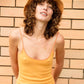 Lifestyle image of Saturday Bucket Hat – Tangerine by FallenBROKENstreet. Model in bright dress wearing cotton chenille bucket hat with wide brim and UPF 50+ protection. Styled in golden hour light, capturing relaxed festival-ready energy.