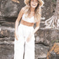 The Seeker Straw Hat styled in a beachside or natural landscape setting, embodying a laid-back, free-spirited summer aesthetic.