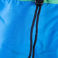 Close-up drawstring – Detail of adjustable black drawcord on blue nylon cape, sun hat design feature.

