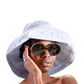 Close-up of model in FallenBROKENstreet Sunday Hat in light blue, paired with statement sunglasses.
