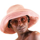 Side profile of woman wearing The Sunday hat in pink corduroy with wide brim, showing its breathable, casual fit and signature button detail.

