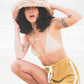 Model wearing the Sunday Bucket Hat – Paisley by FallenBROKENstreet. Lightweight cotton canvas bucket hat with wide brim and all-over paisley print. Styled with a crochet bikini top and shorts at the beach, highlighting its unisex, travel-ready design made for sun protection and coastal adventures.
