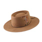 The Notebook hat in vintage tan shown front-on, highlighting its stiff wide brim, patina finish, waxed rope band, and custom feather—each piece unique.

