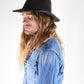 Man wearing a black hat and blue denim shirt against a white background