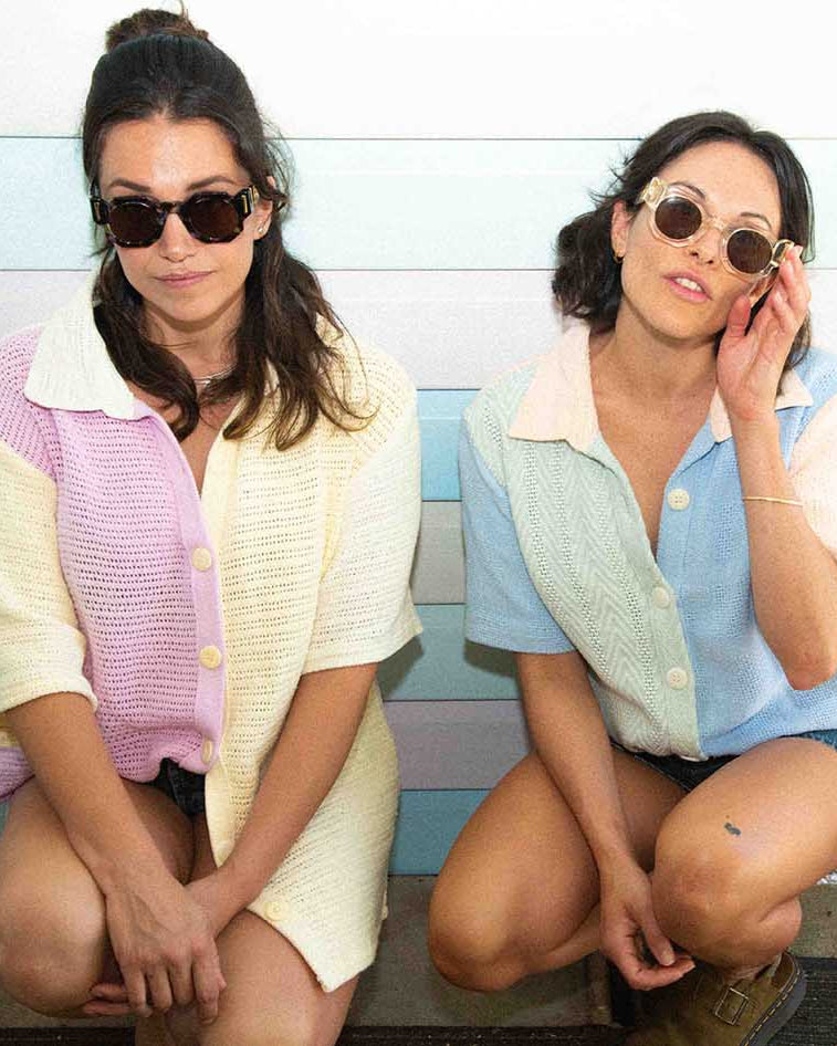 Two woman wearing fallen broken street cosmos sunglasses. One woman is wearing clear acetate sunglasses the other is wearing tortoise shell sunglasses. they are knell wearing vintage shirts in Brunswick heads