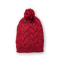 • The Consciousness Beanie red close-up showing cable knit pattern and pom detail with soft fibres
