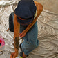 Model painting while wearing The Original Kyte Cap – Dark Indigo at the David Bromley Estate. Unisex denim cap with rope band and leather inner lining.