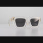 video Folded view of The Mischief sunglasses showcasing both sides and arms. White acetate and black lenses highlighted against a soft grey backdrop.

