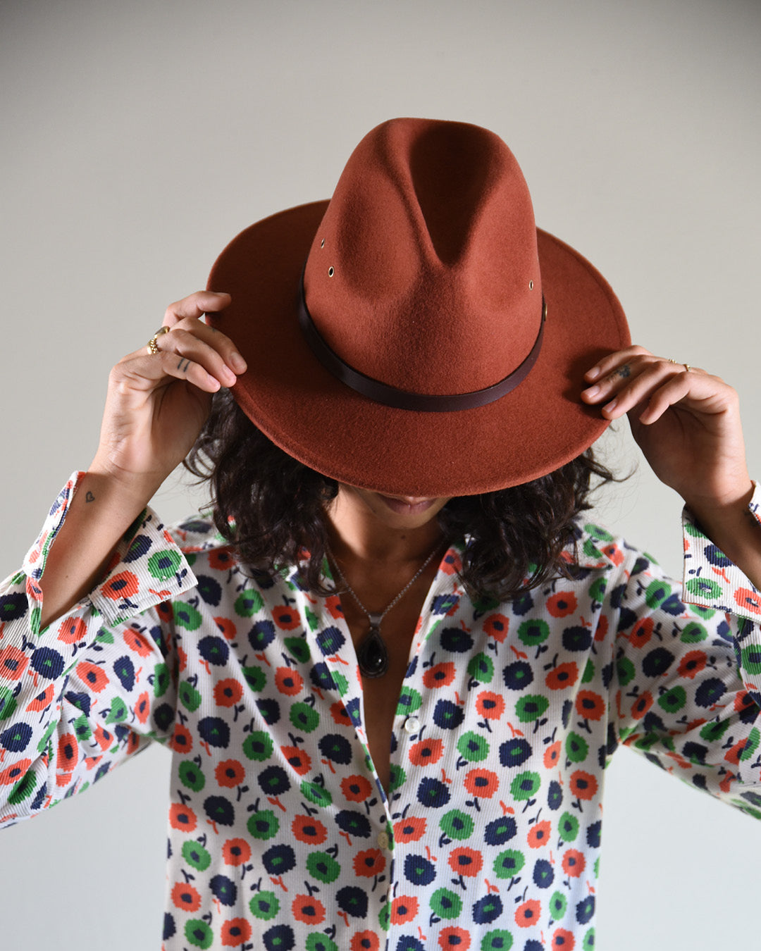 Woman wearing a rust coloured felt fedora